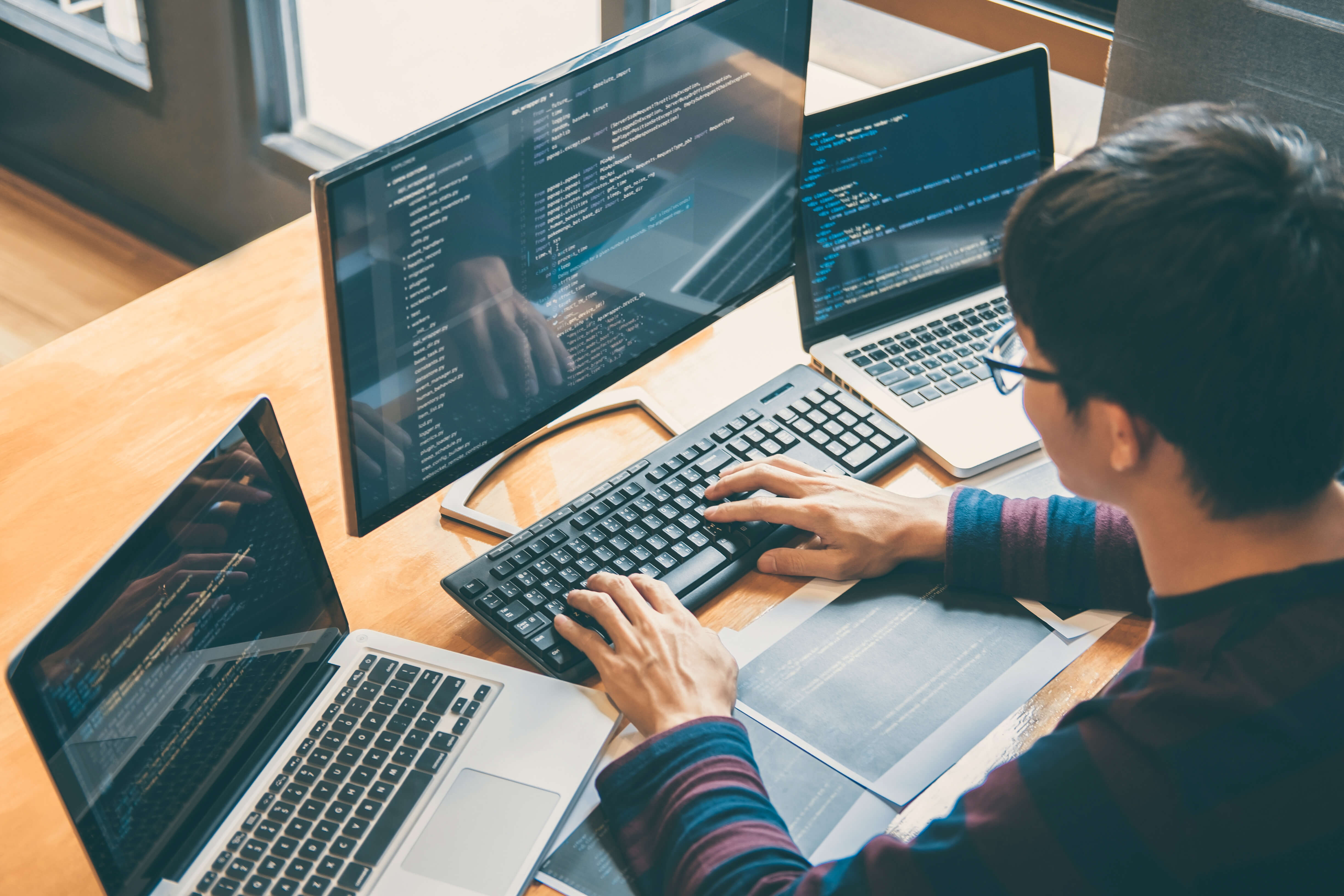 components/Developer_monitoring_three_screens.jpg